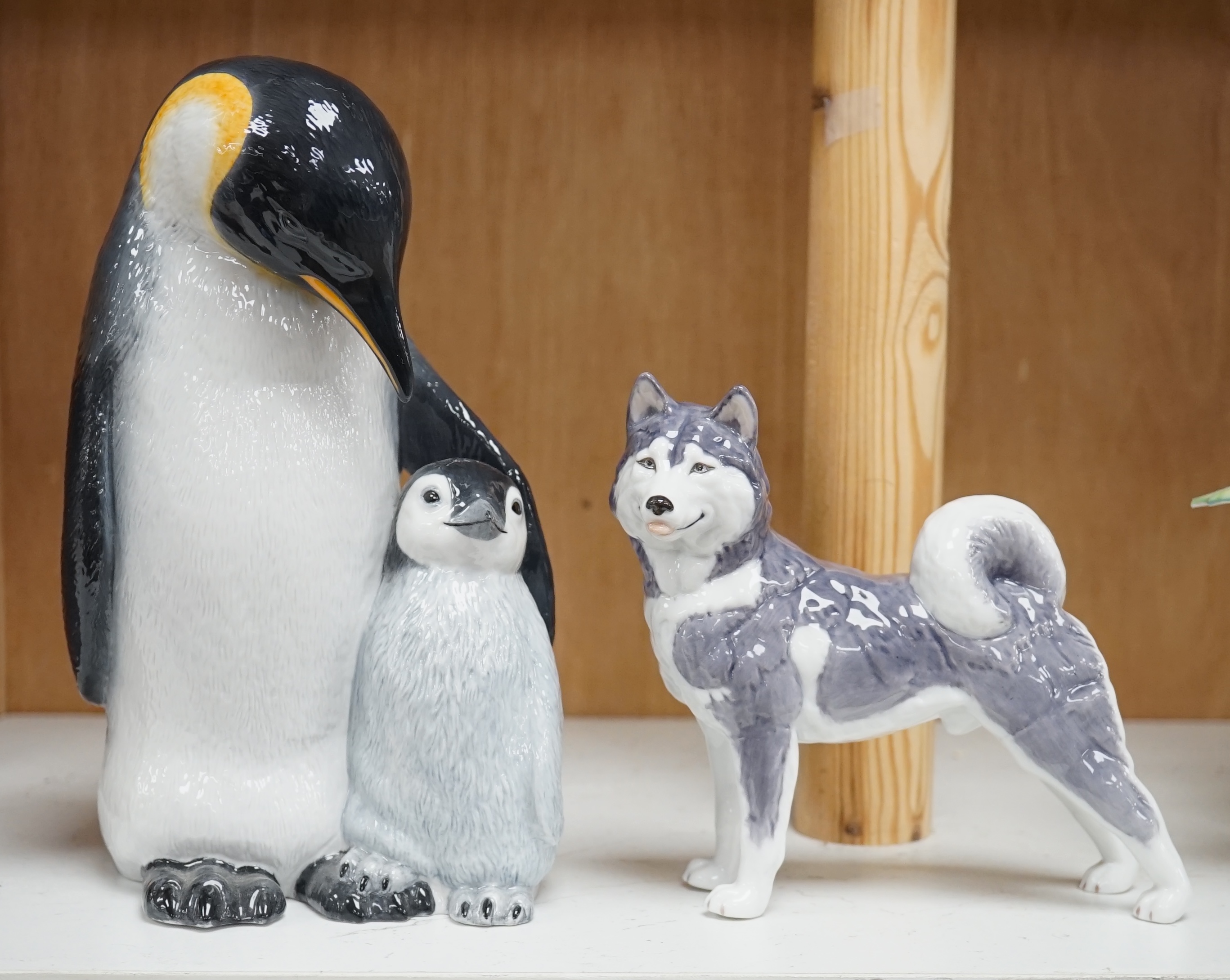 A Royal Copenhagen penguin group and a similar husky figure, 088 and 038, tallest 22cm. Condition - good